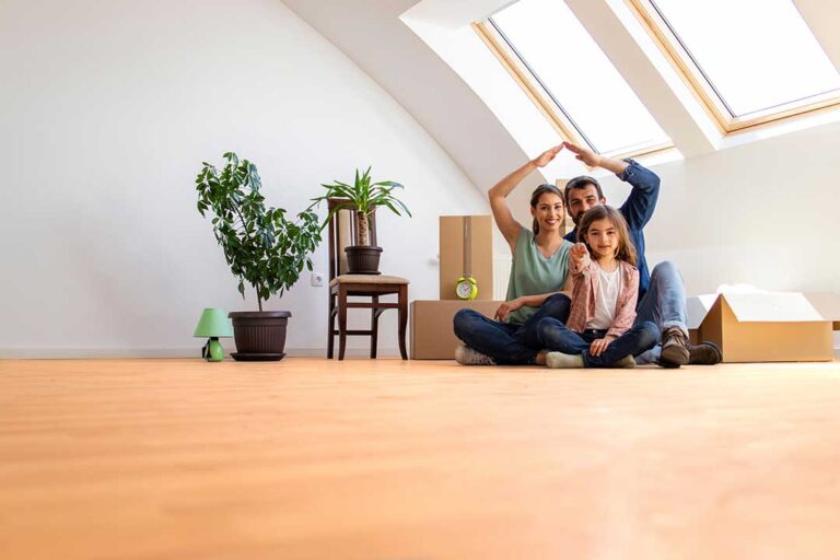 Homebuyers review a purchase offer and inspection report at a kitchen table.